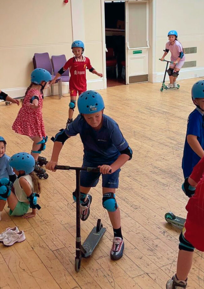 Young person attending a Wheels Extreme workshop playing on a scooter in The Bronte Youth and Community Centre