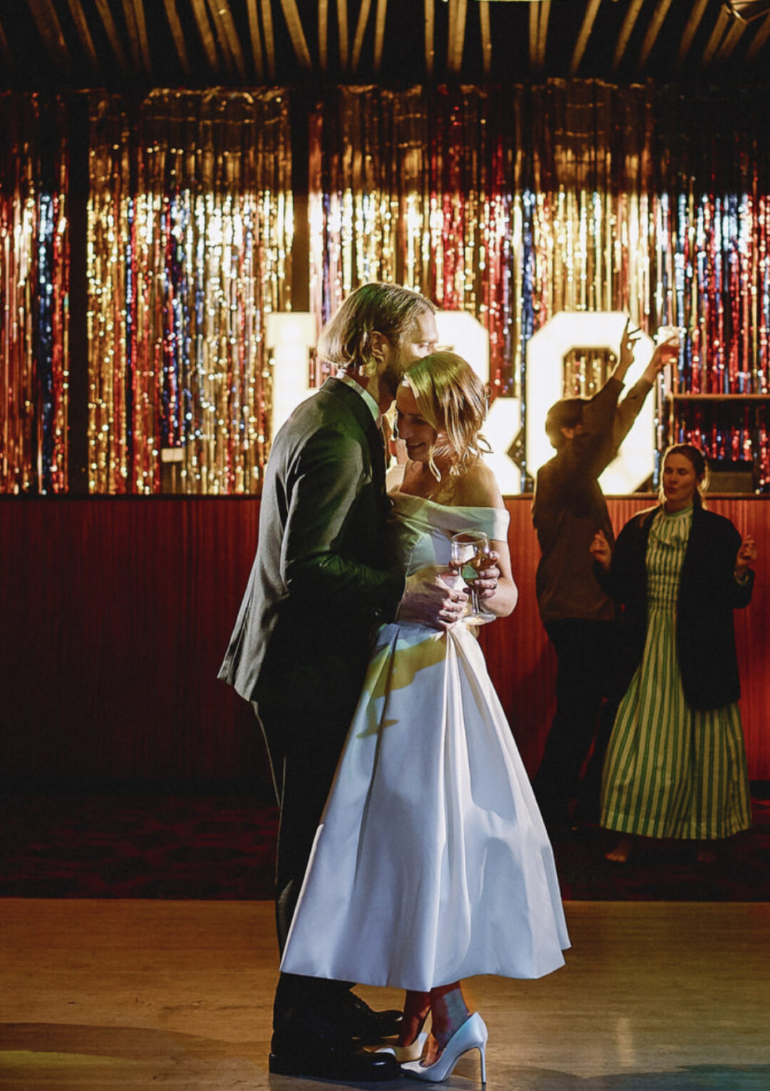 Couple during their first dance after their wedding in a decorated event space