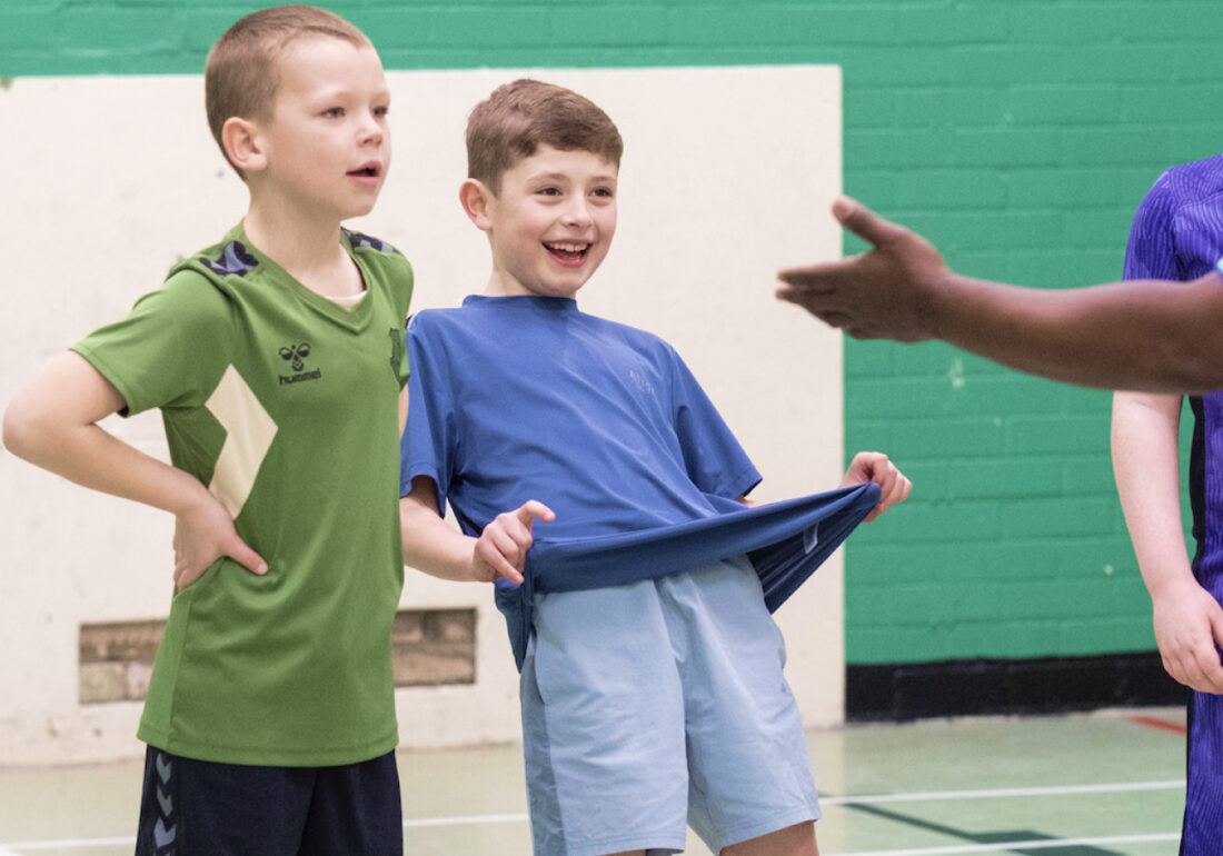 Two young members of The Bronte youth club playing football in the sports hall at The Bronte Youth and Community Centre based in Liverpool City Centre