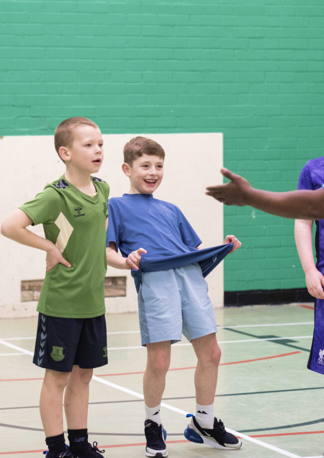 Two young members of The Bronte youth club playing football in the sports hall at The Bronte Youth and Community Centre based in Liverpool City Centre