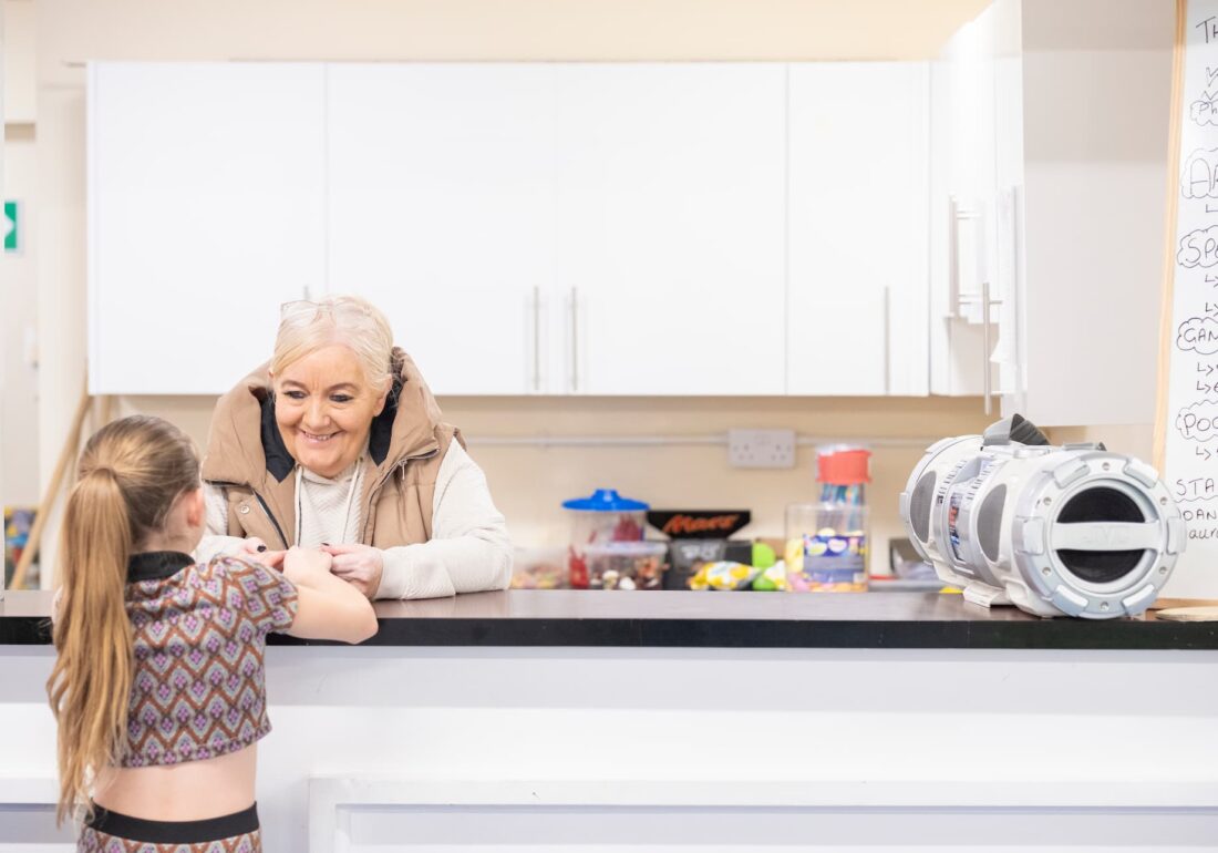 A young person at the Bronte tuck shop talking with a member of staff at The Bronte Youth and Community Centre based in Liverpool City Centre