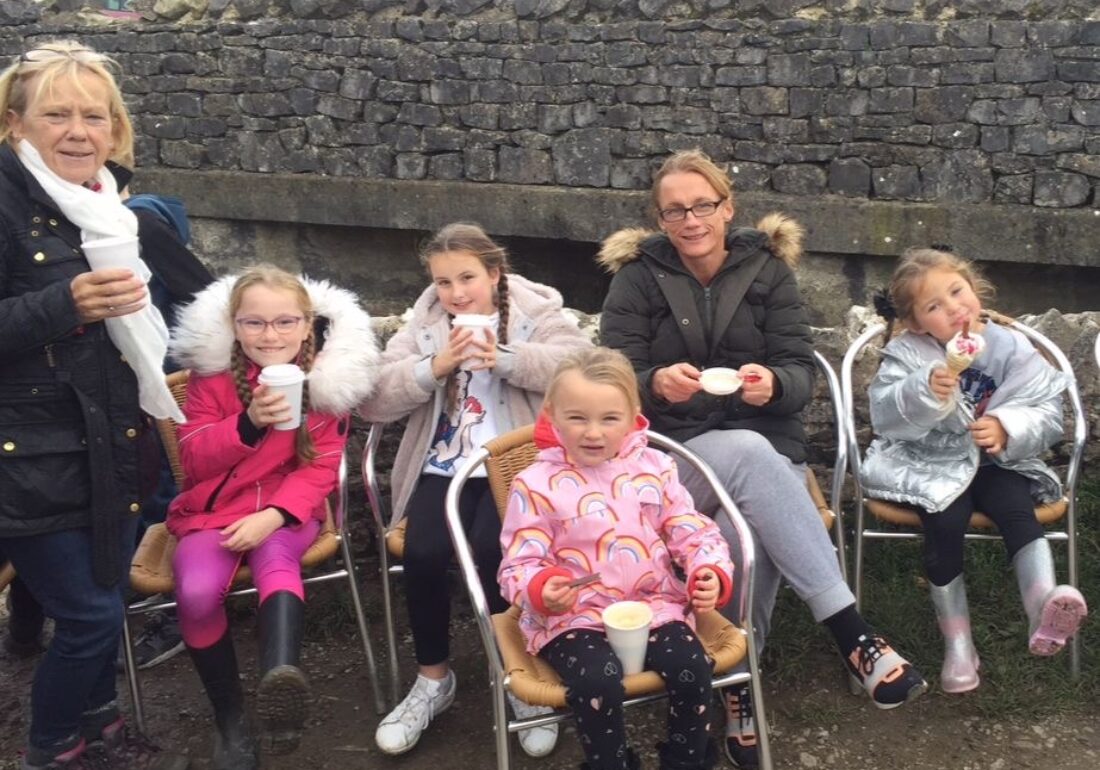 Children, parents and staff enjoying ice cream and tea on scenic walk in Yorkshire during a Bronte Youth Club residential.