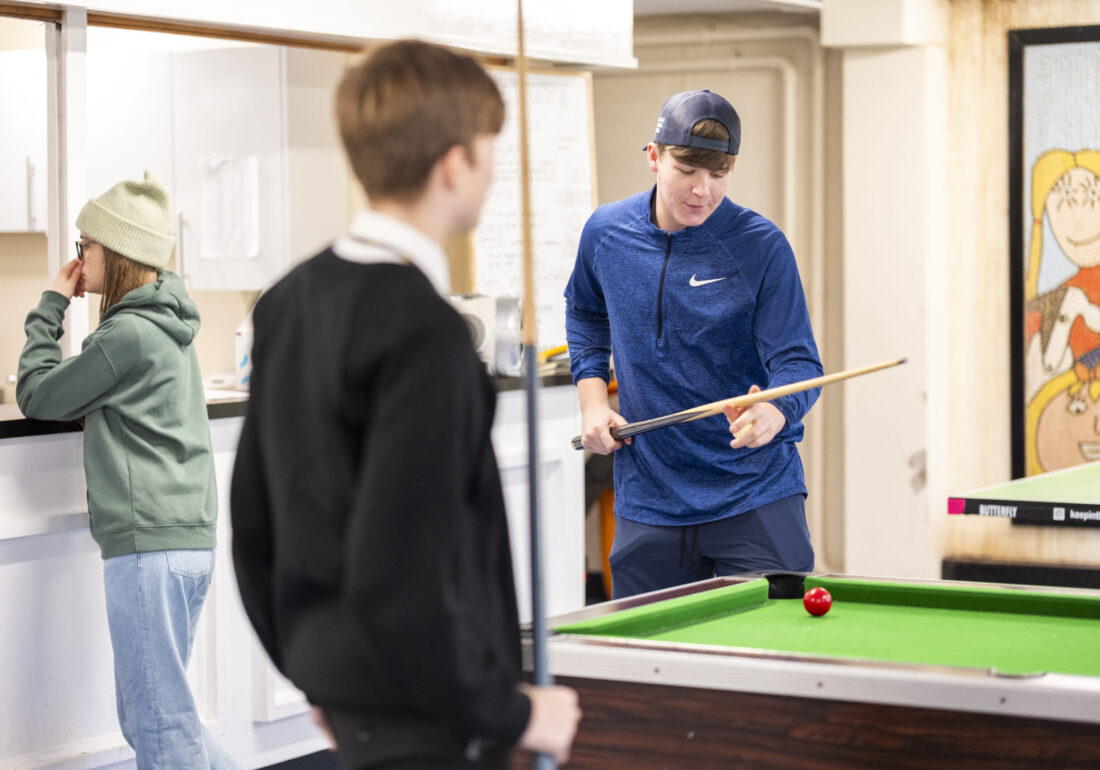 Two teenagers playing pool at the Bronte Youth and Community Centre, enjoying a fun and social game in a vibrant community space.
