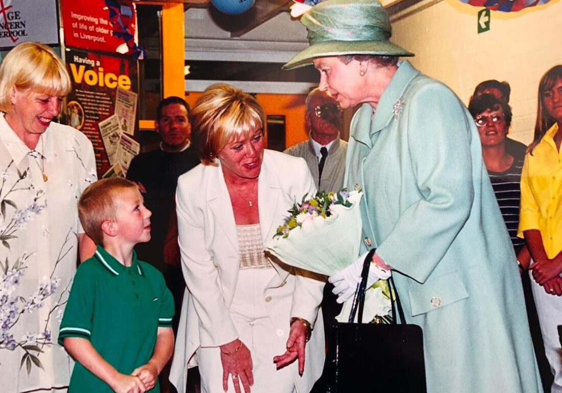 Historic photo of former Centre Manager, Mary, volunteers and young people meeting Queen Elizabeth II during her visit to the Bronte Youth and Community Centre based in Liverpool City Centre in the 1990's